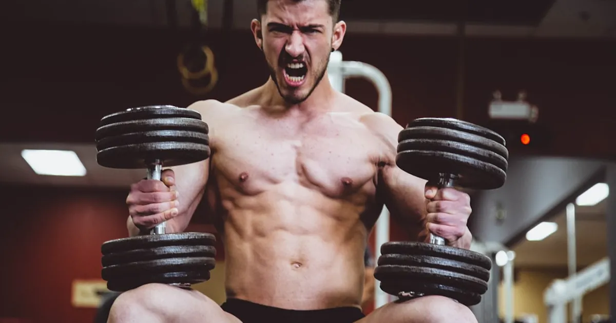 man holding two dumbbells