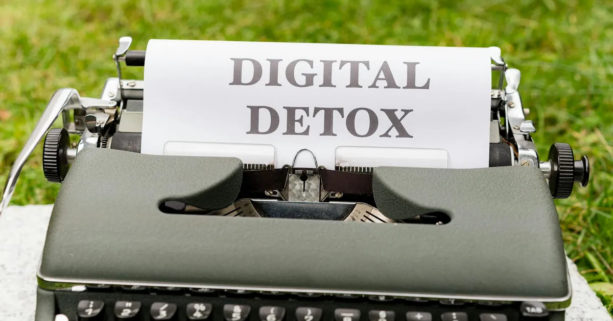 A classic typewriter displaying the words 'Digital Detox' outdoors, symbolizing a break from technology.