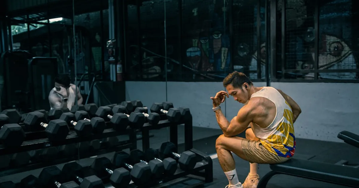 A man sitting on a bench in a gym A man sitting on a bench in a gym