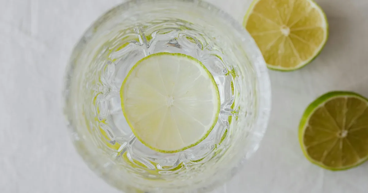 Top view of a refreshing lime-infused water with citrus slices in a crystal glass.