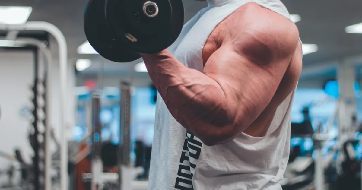man in white tank top lifting black dumbbell man in white tank top lifting black dumbbell