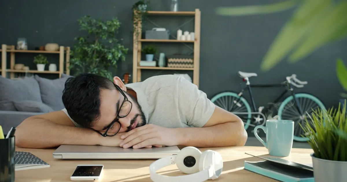Man sleeping on a laptop at a desk Man sleeping on a laptop at a desk